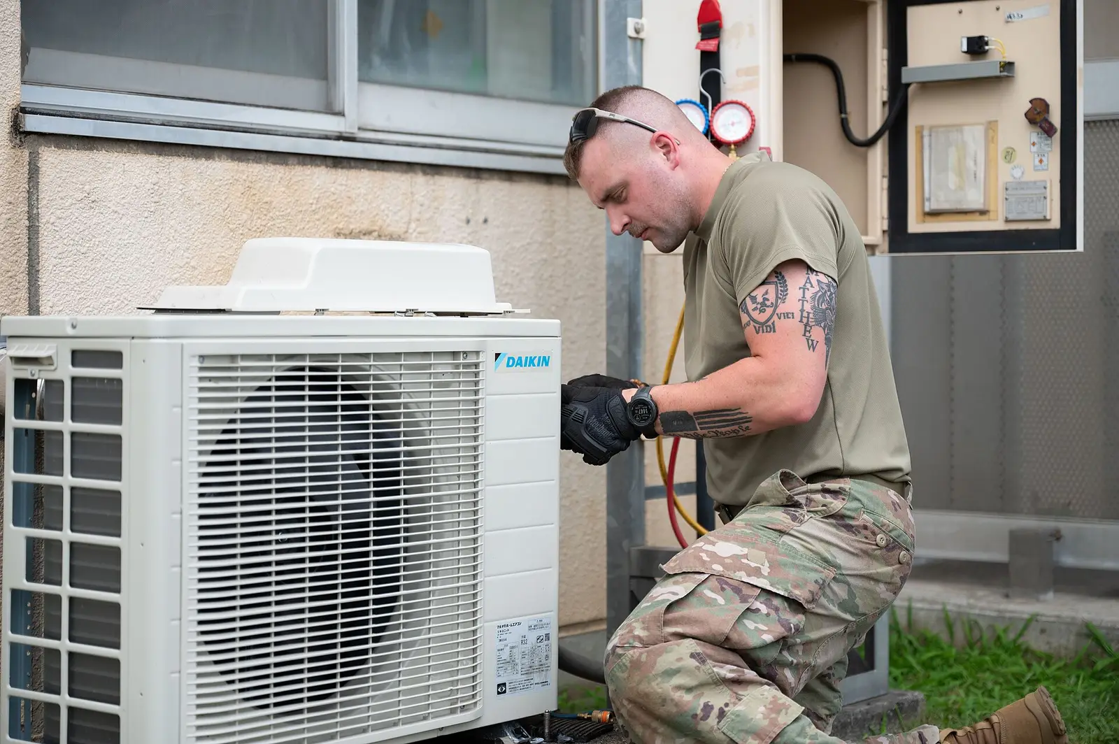 A technician servicing the outdoor unit of a heat pump