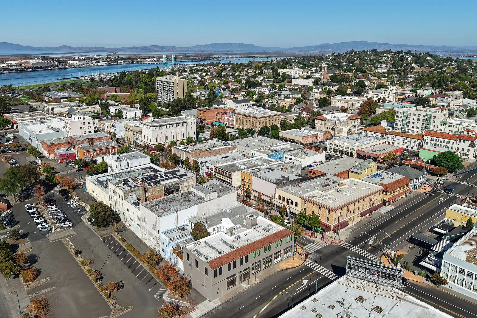 Aerial view of downtown Vallejo: low commercial blocks, houses climbing the hills behind, and the waterfront in the distance