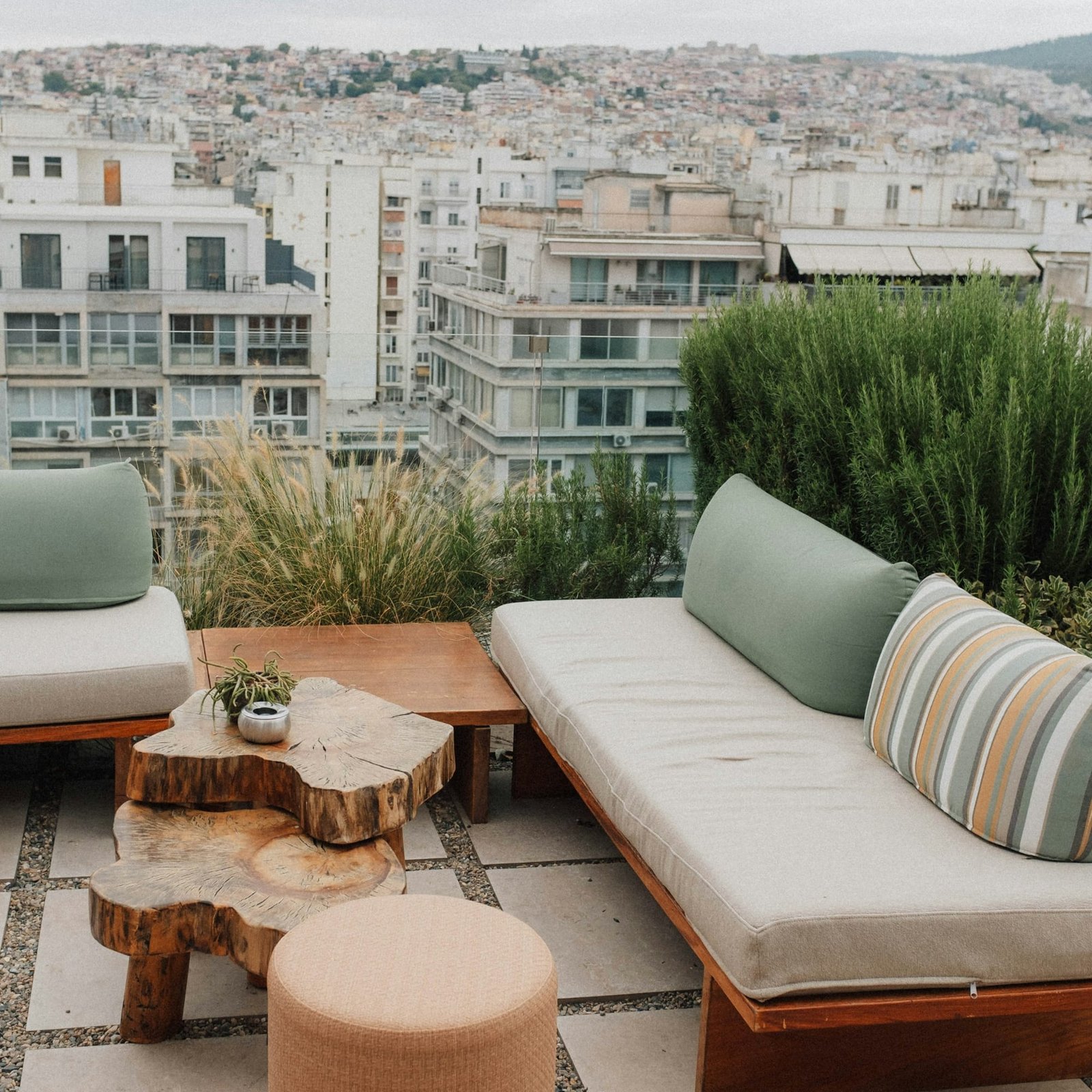 Rooftop patio with a wooden sofa, cushions and a log coffee table