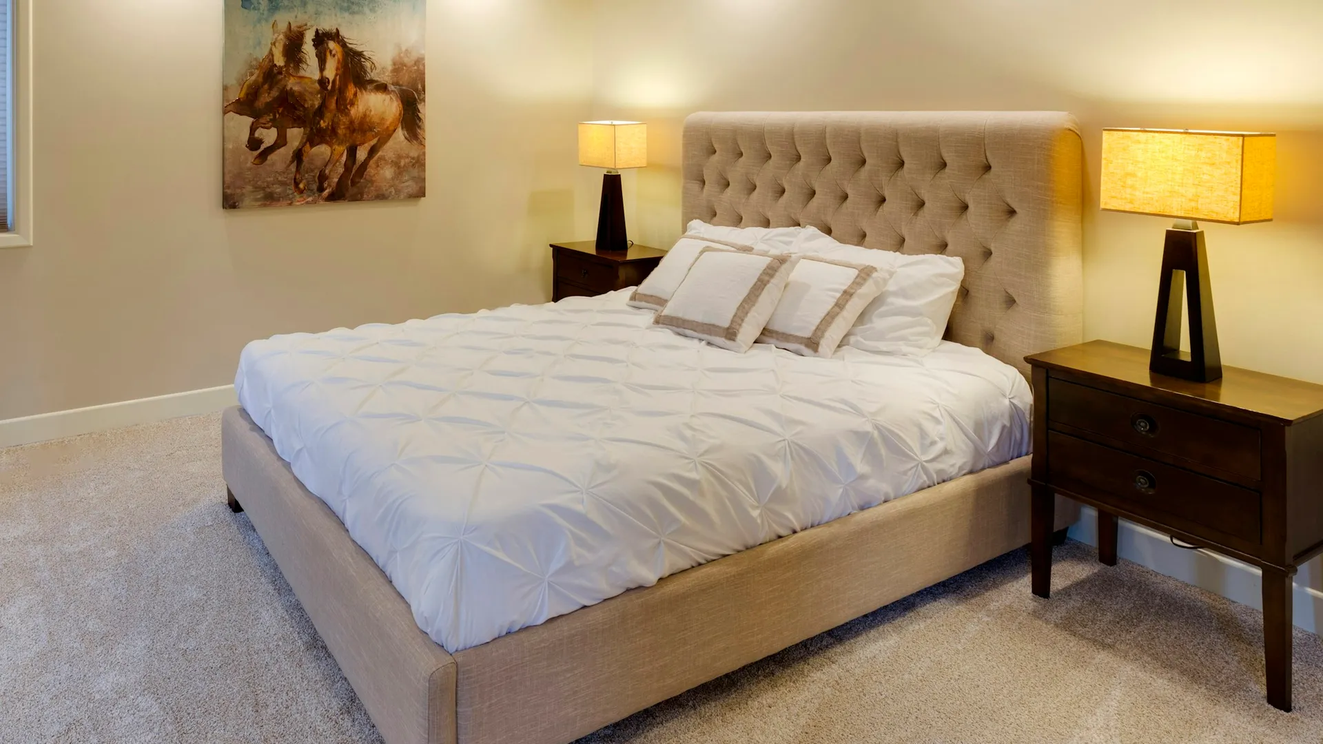 Upholstered bed frame with tufted headboard set up in a carpeted bedroom