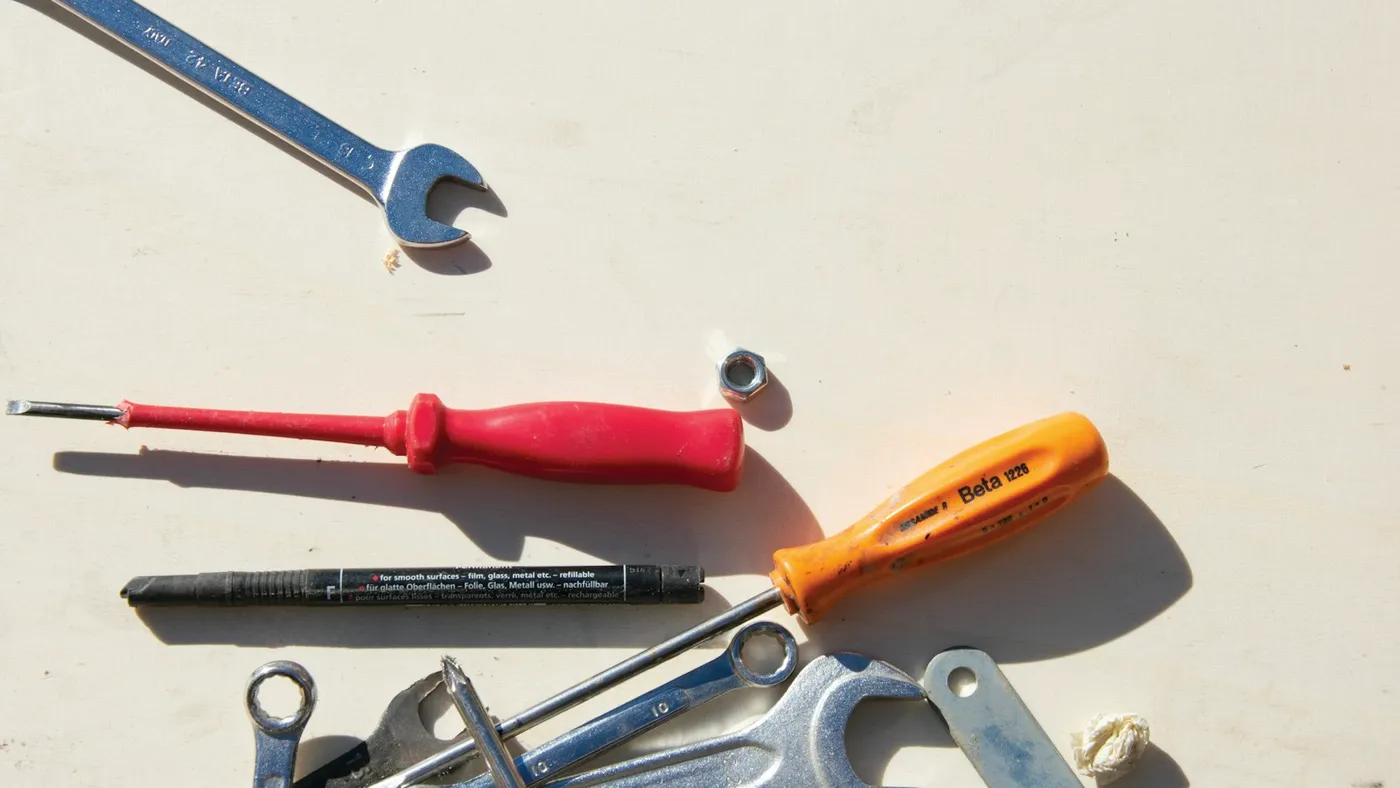 Wrenches and screwdrivers laid out on a light work surface