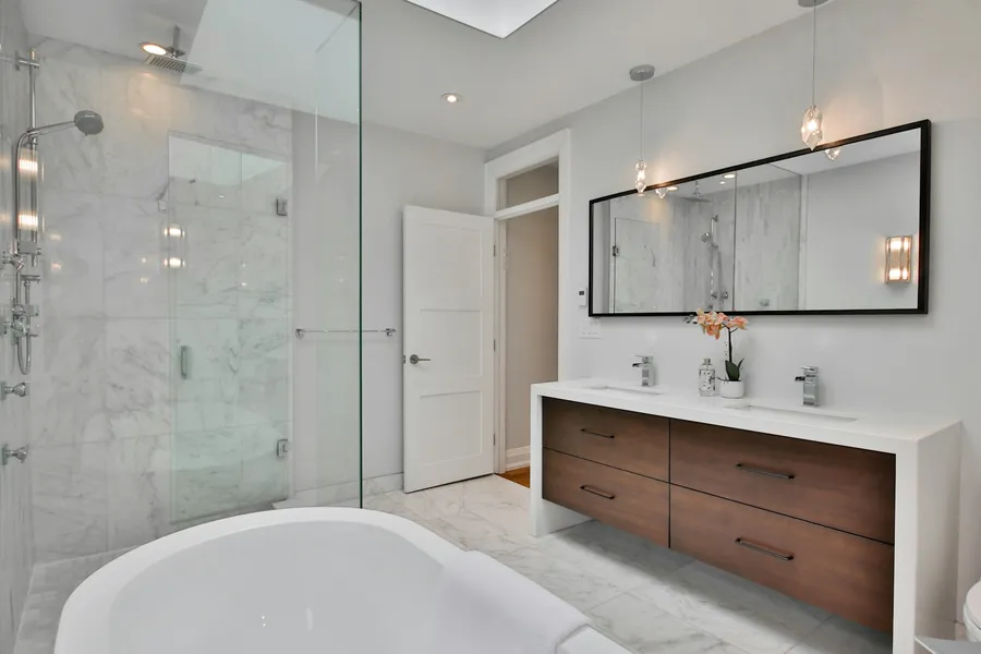 Bathroom with a floating wood vanity, glass walk-in shower and freestanding tub