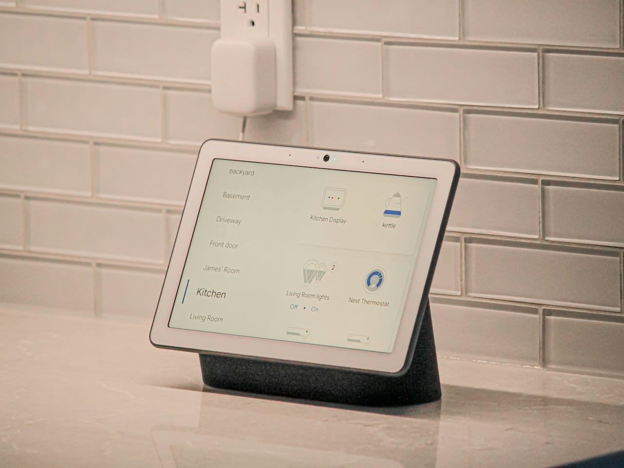 Smart home display showing room controls on a kitchen counter