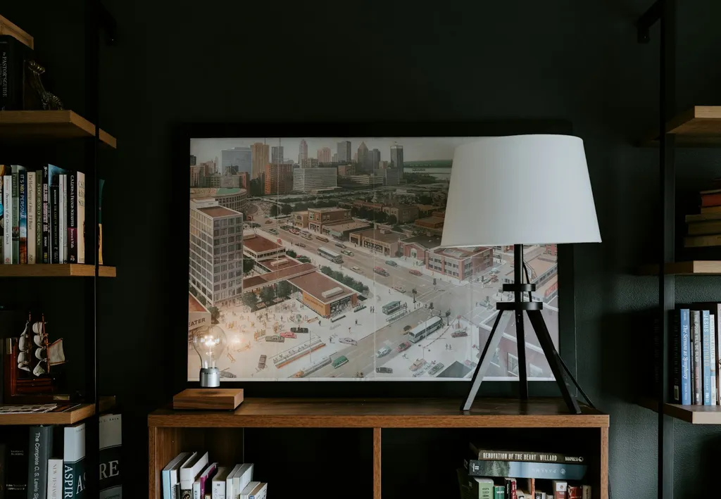 Wall shelves filled with books flanking a framed print and a lamp