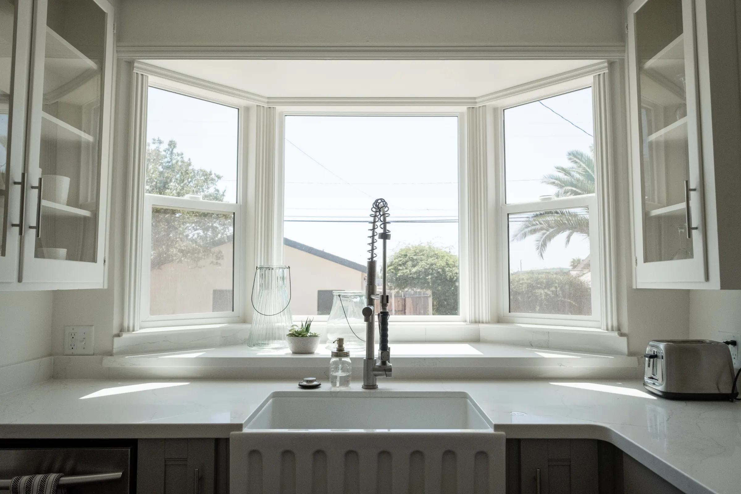 Bright kitchen with a farmhouse sink under a bay window