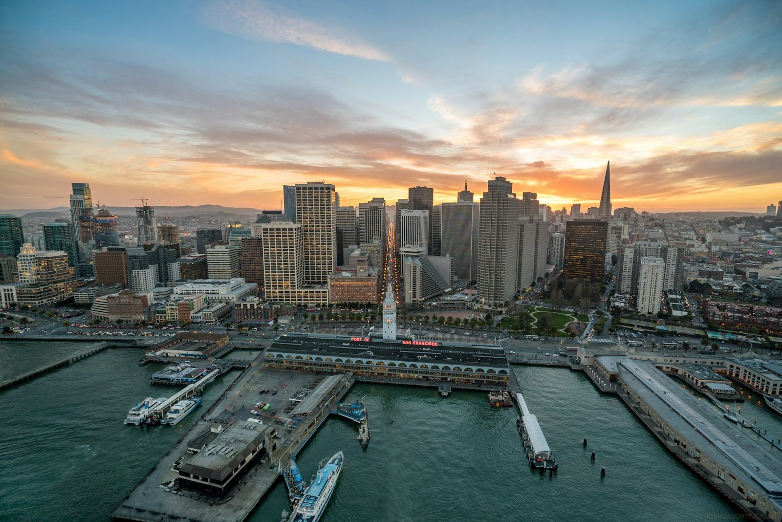 Aerial view of the Ferry Building piers and downtown San Francisco at sunset
